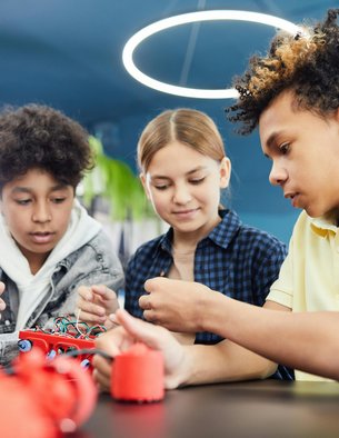 Three youth engage in a STEM activity.